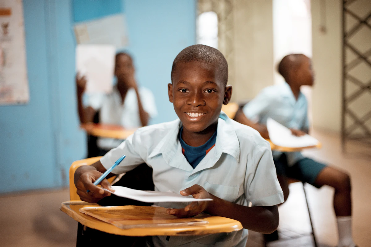 Un collégien écrit à son pupitre